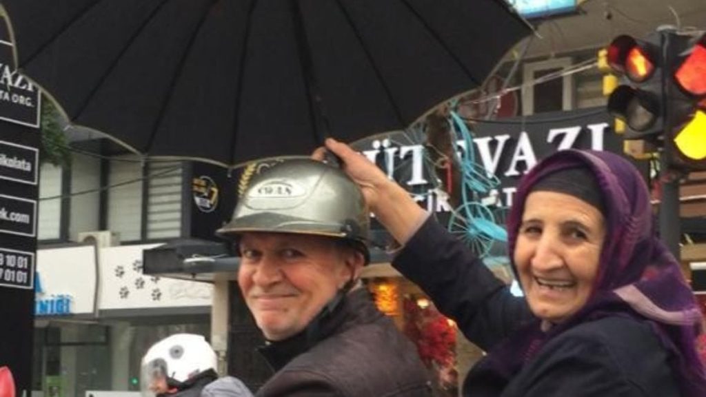 Adana’da sağanak yağışta kocasına şemsiye tuttu